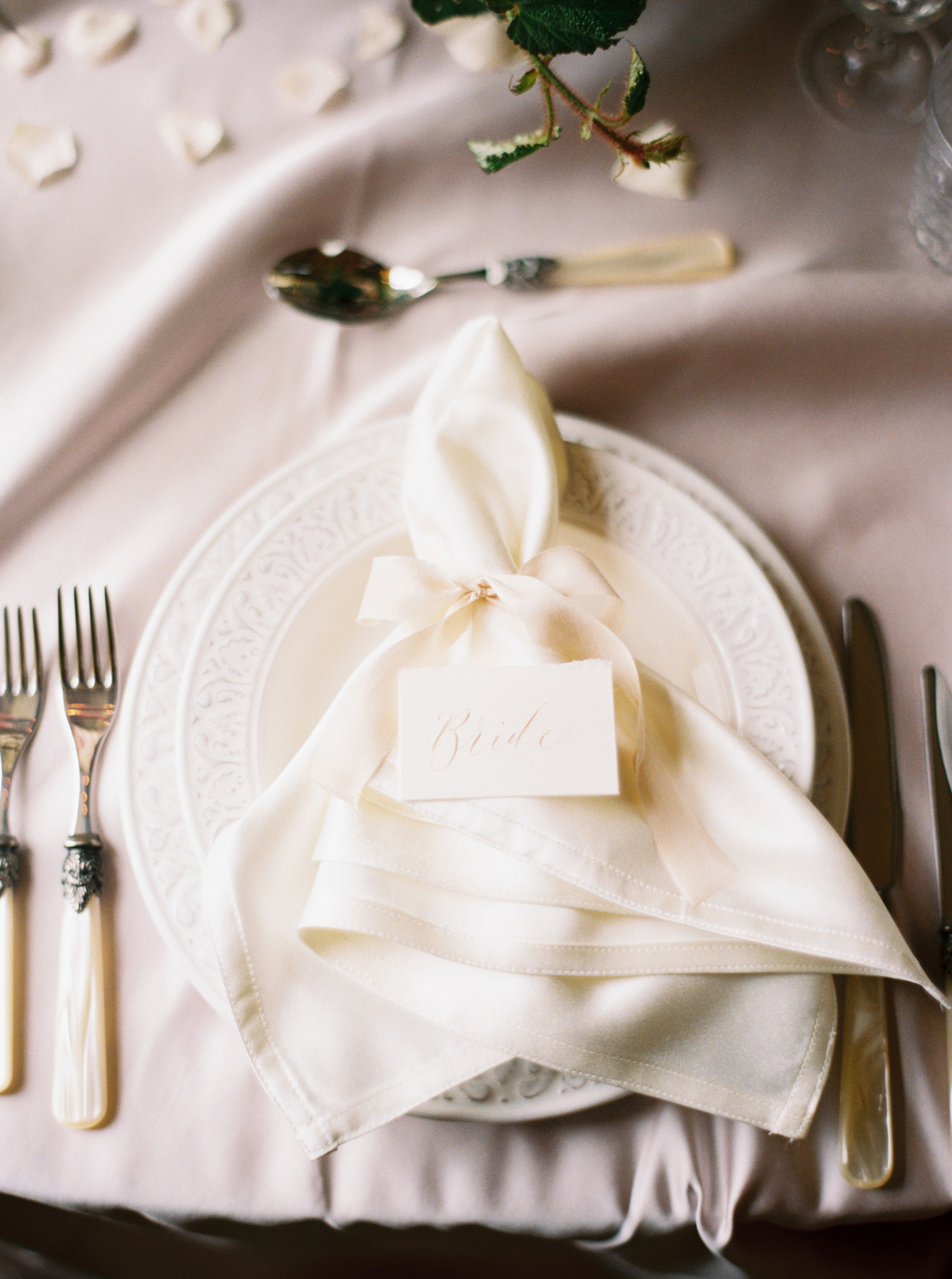 a soft silk wedding napkin with a calligraphy place name card on top