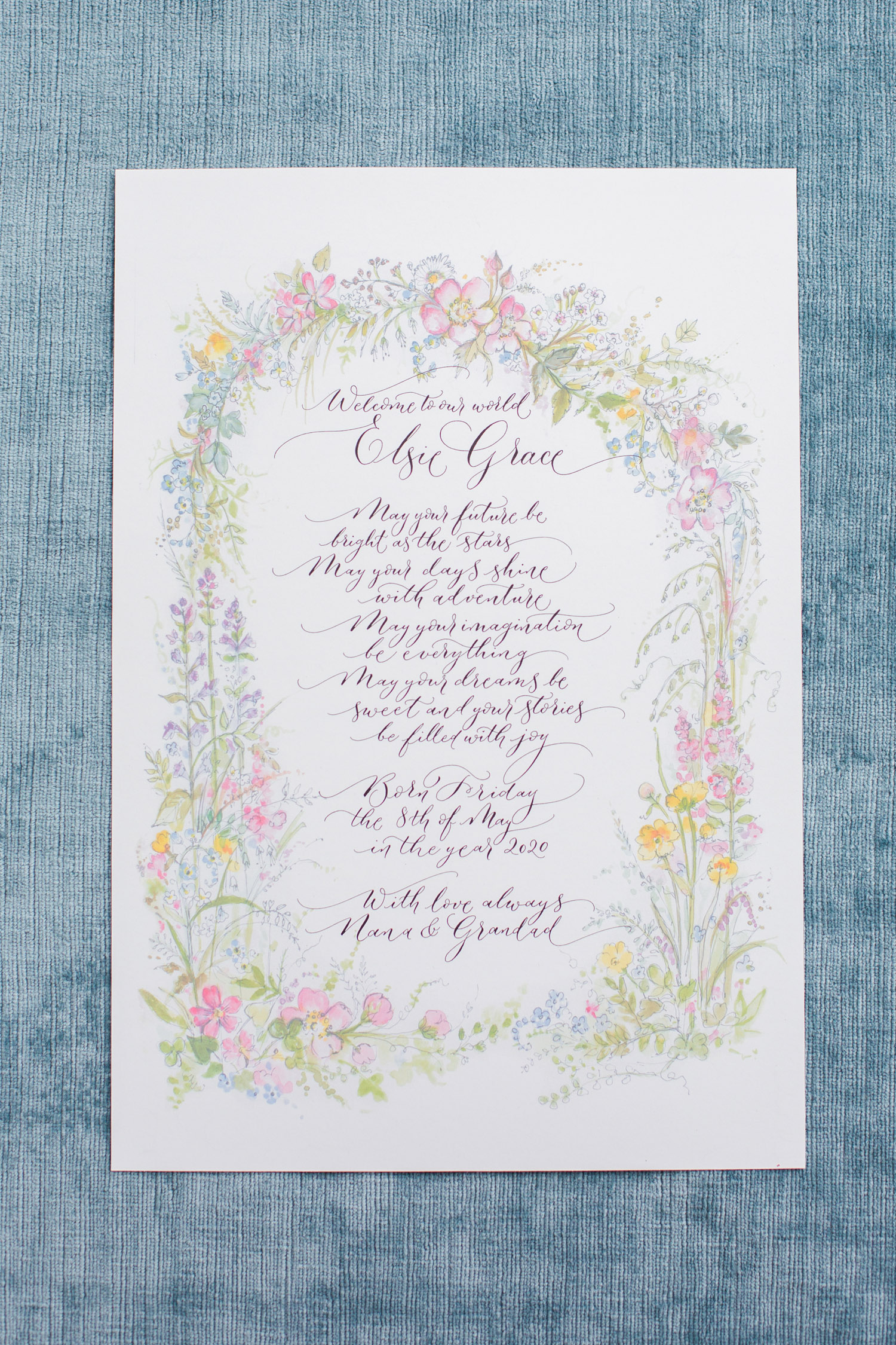 A calligraphy certificate welcoming a new baby, with floral illustrations by Amy Swann. 