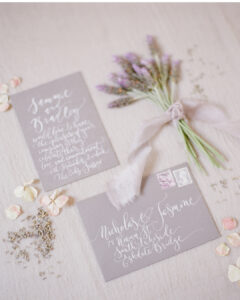 calligraphy invitation with matching handwritten envelope in white ink on dove grey card