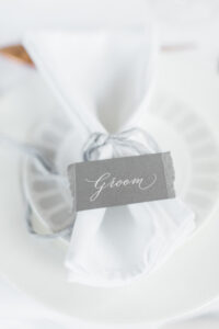 white ink wedding place name on grey card with torn edges