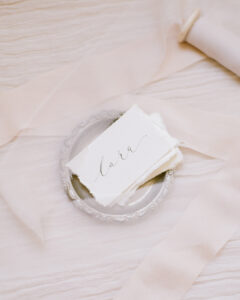 Cotton rag wedding place names with delicate modern calligraphy in a little silver bowl