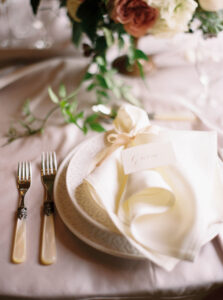Ivory wedding napkin on plates with a calligraphy place name