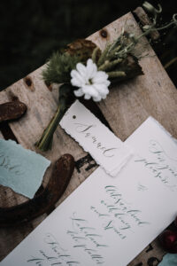 rustic wedding calligraphy place names in dark green ink on white torn edge art paper
