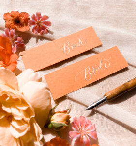 mandarin orange wedding place name cards in calligraphy