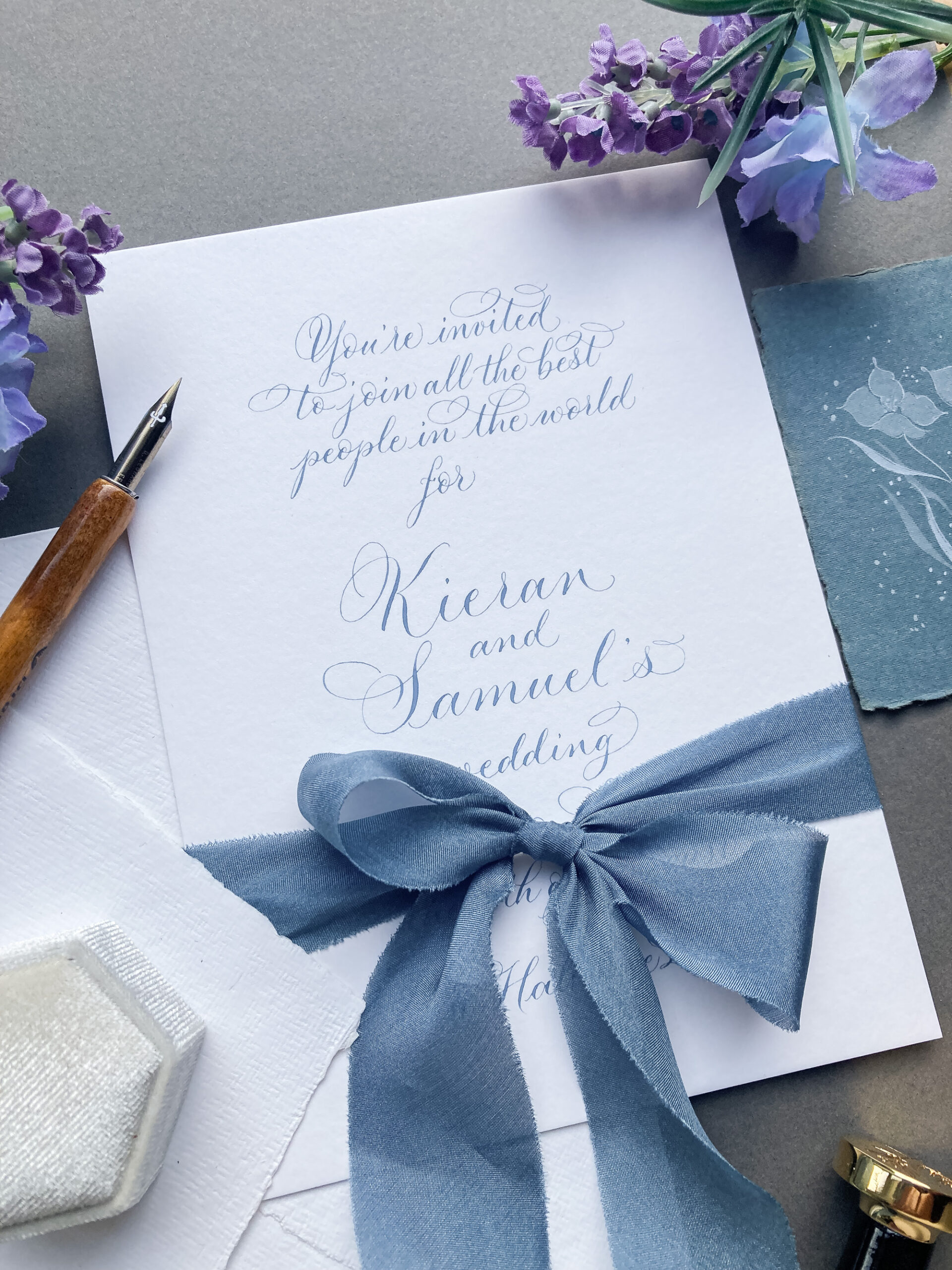 handwritten wedding invitations by a UK calligrapher in blue ink with silk ribbon