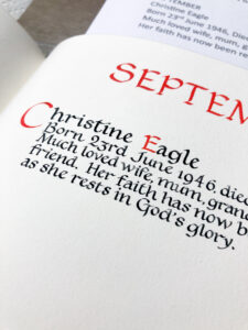 Work of a calligrapher in a book of remembrance showing red and black lettering